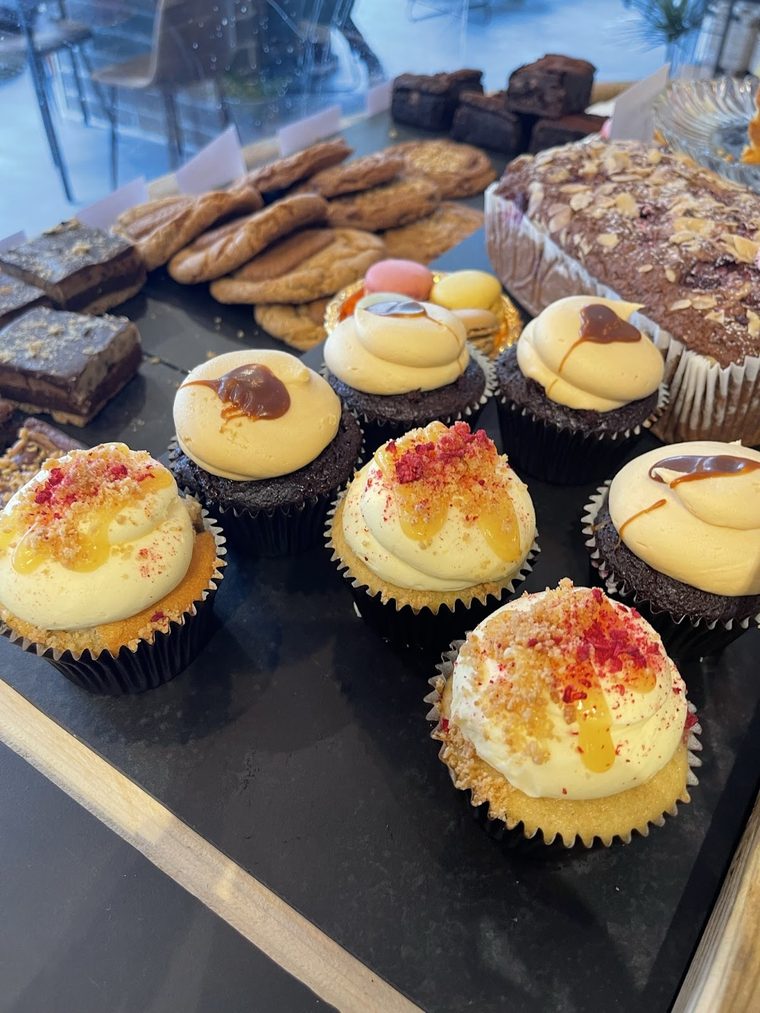 Frosted cupcakes, cookies and brownies in the counter display